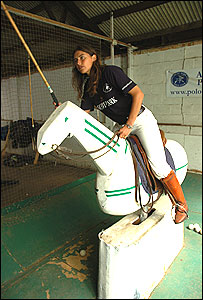 Victoria Grace demonstrates a polo swing from a wooden teaching horse